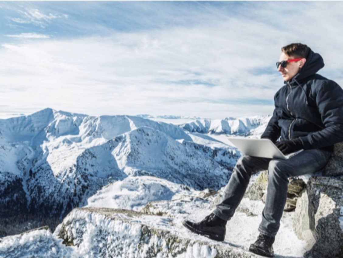 Stock photo mann med pc på fjelltopp
