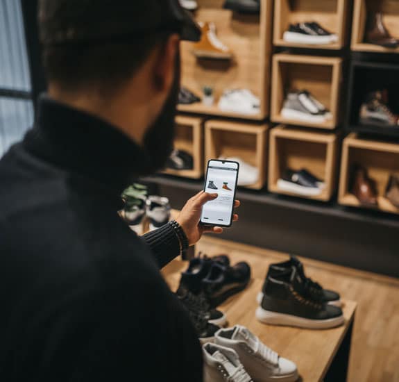 Bilde av mann som holder en telefon i butikk